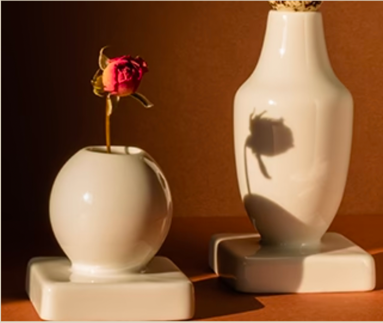 White ceramic vases with a red rose in it