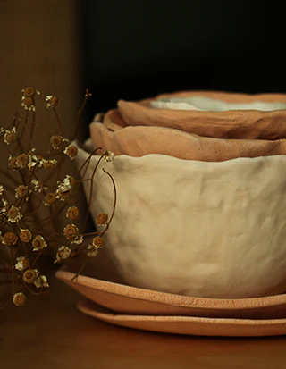 Brown and beige clay bowls and plates stacked on each other