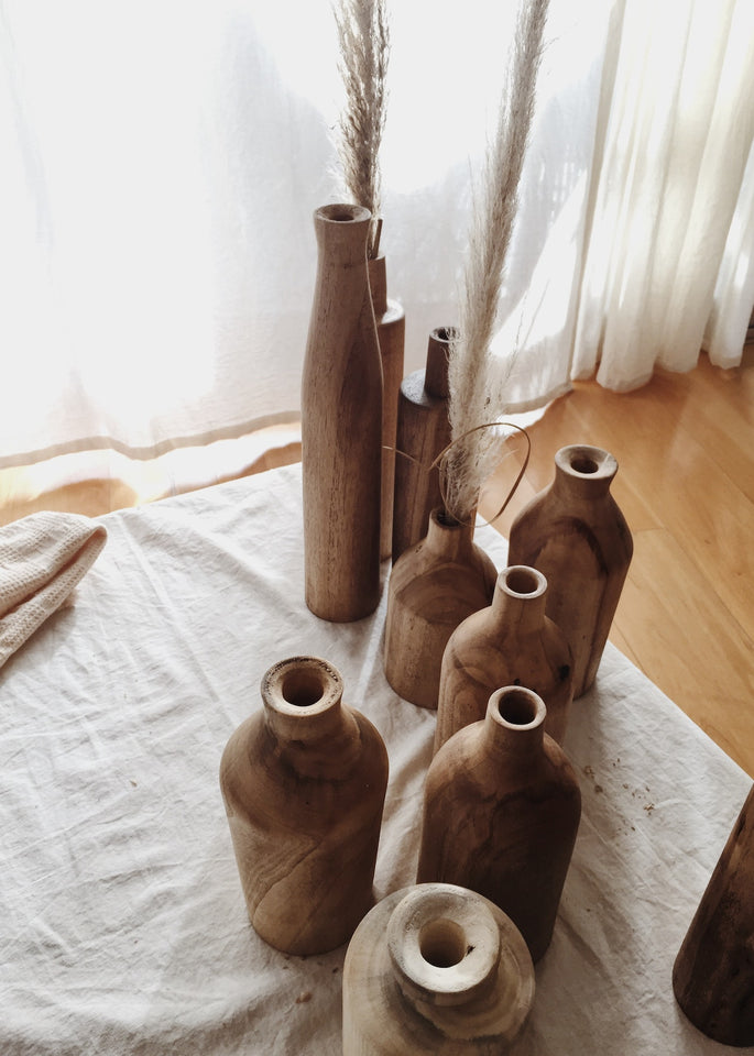 Collection of brown vases with dried out straw in them